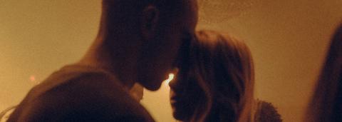 Photo de deux personnes la tête l'un contre l'autre lors d'un fête, la lumière est tamisé