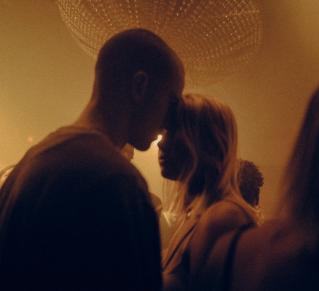 Photo de deux personnes la tête l'un contre l'autre lors d'un fête, la lumière est tamisée