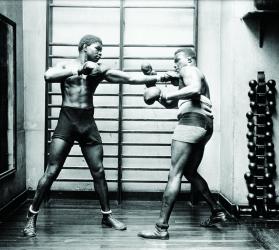 Photo en noir et blanc d'une scène de boxe sur un ring