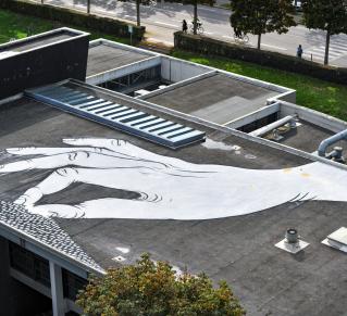 Fresque d'une main blanche sur un toit