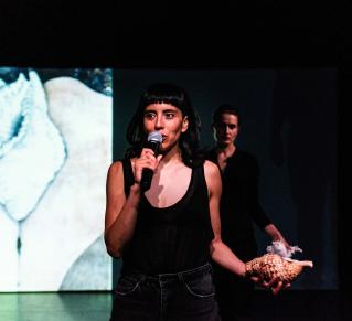 Une femme tenant un coquillage