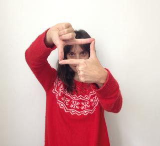 Photo d'une femme en pull rouge, qui avec ses mains cadre.