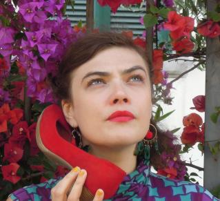 Rosemary Standley utilise une chaussure rouge comme combiné téléphonique.