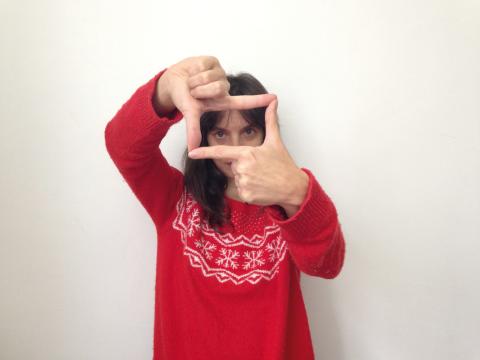 Photo d'une femme en pull rouge, qui avec ses mains cadre.