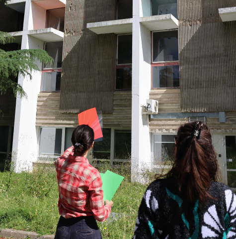 Manon Giovani, étudiante en Master médiation du Patrimoine lors d'une visite des oeuvres du campus Villejean, tenant dan ss amain des calques de couleur, pour présenter une oeuvre face à elle.