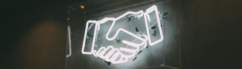 Vue sur un néon en forme de poignée de main