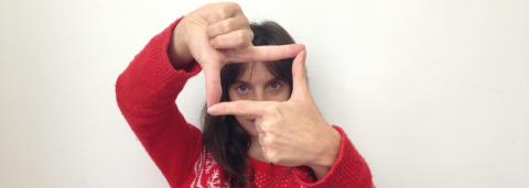 Photo d'une femme en pull rouge, qui avec ses mains cadre.