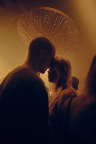 Photo de deux personnes la tête l'un contre l'autre lors d'un fête, la lumière est tamisée